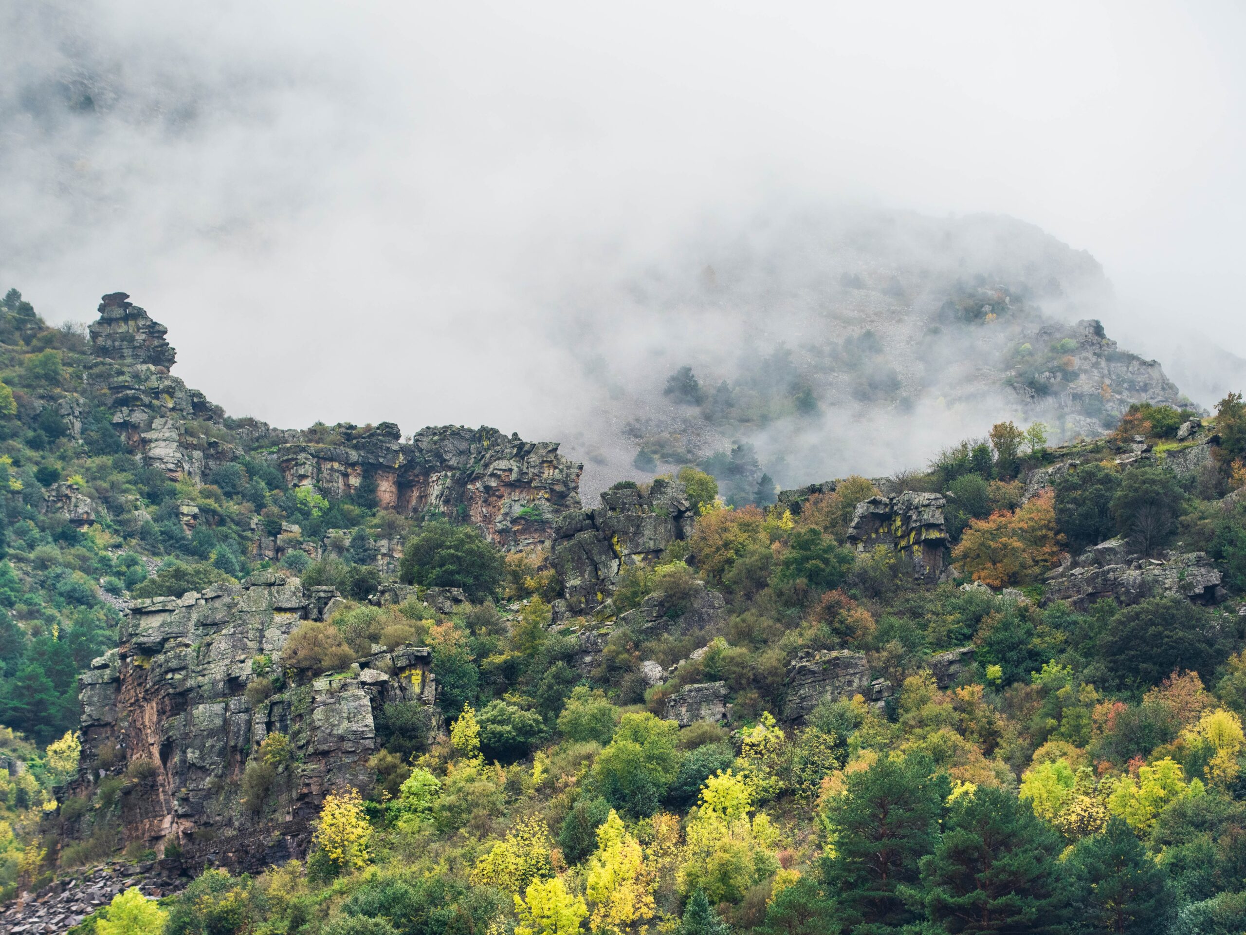 Ladera rocosa entre la niebla en la ruta del Guardián Solitario, macizo del Moncayo